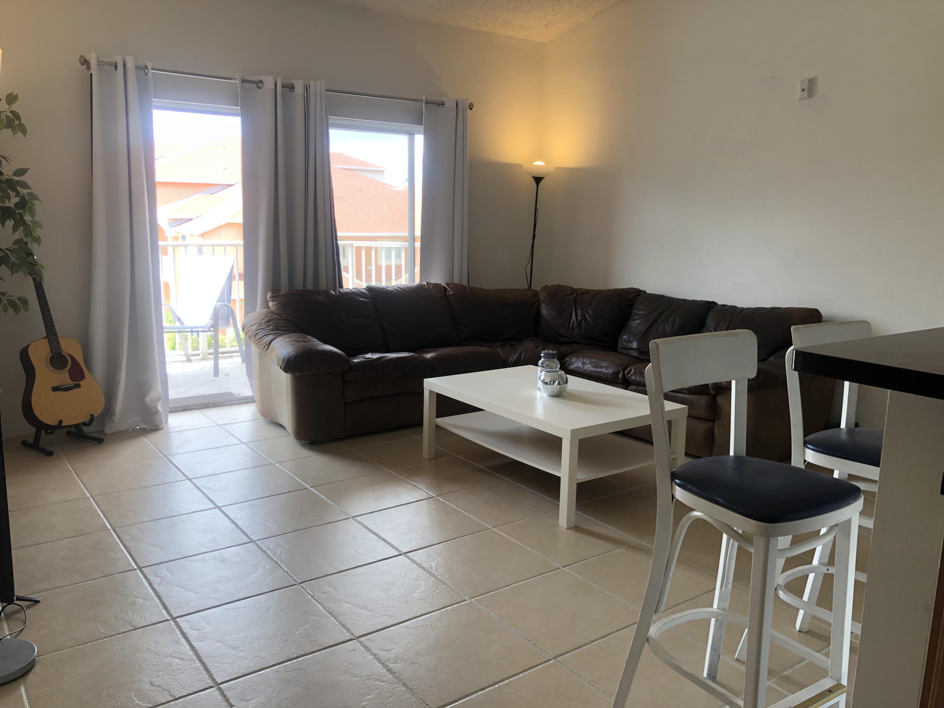 6936 Southwest 39th Street, Unit 304D Davie, FL 33314 - Photo 3 of 25 a living room with furniture a flat screen tv and a window