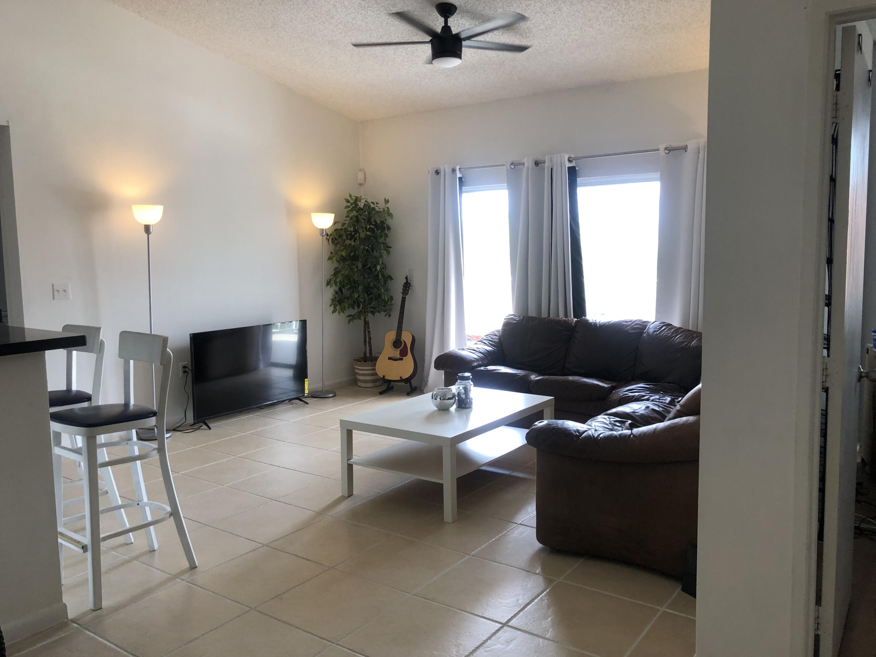 6936 Southwest 39th Street, Unit 304D Davie, FL 33314 - Photo 5 of 25 a living room with furniture and a flat screen tv