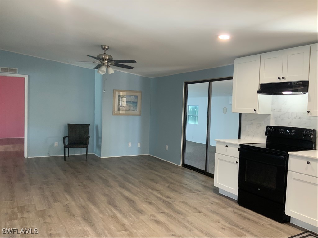 15550 Burnt Store Road, Unit 101 Punta Gorda, FL 33955 - Photo 11 of 28 a view of a kitchen with wooden floor and electronic appliances