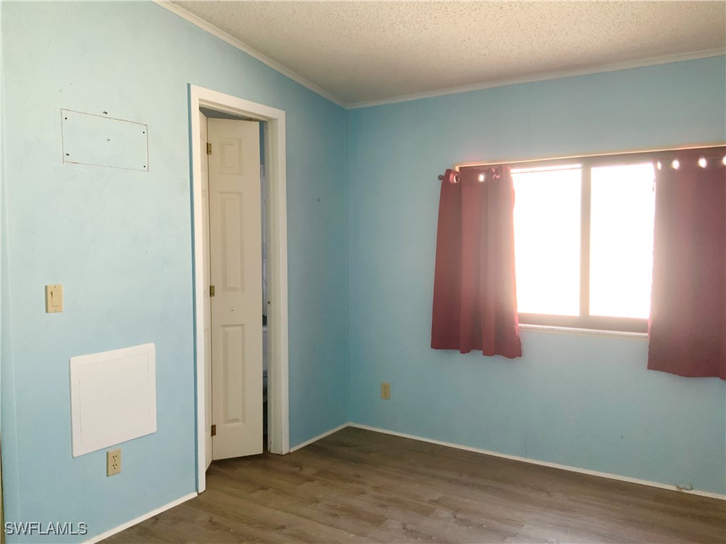 15550 Burnt Store Road, Unit 101 Punta Gorda, FL 33955 - Photo 17 of 28 an empty room with wooden floor and windows