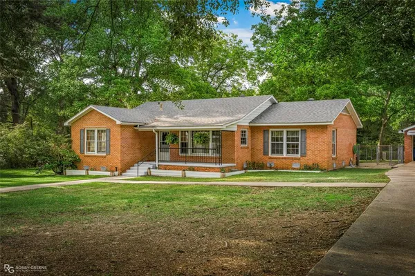 a front view of a house with a yard and trees