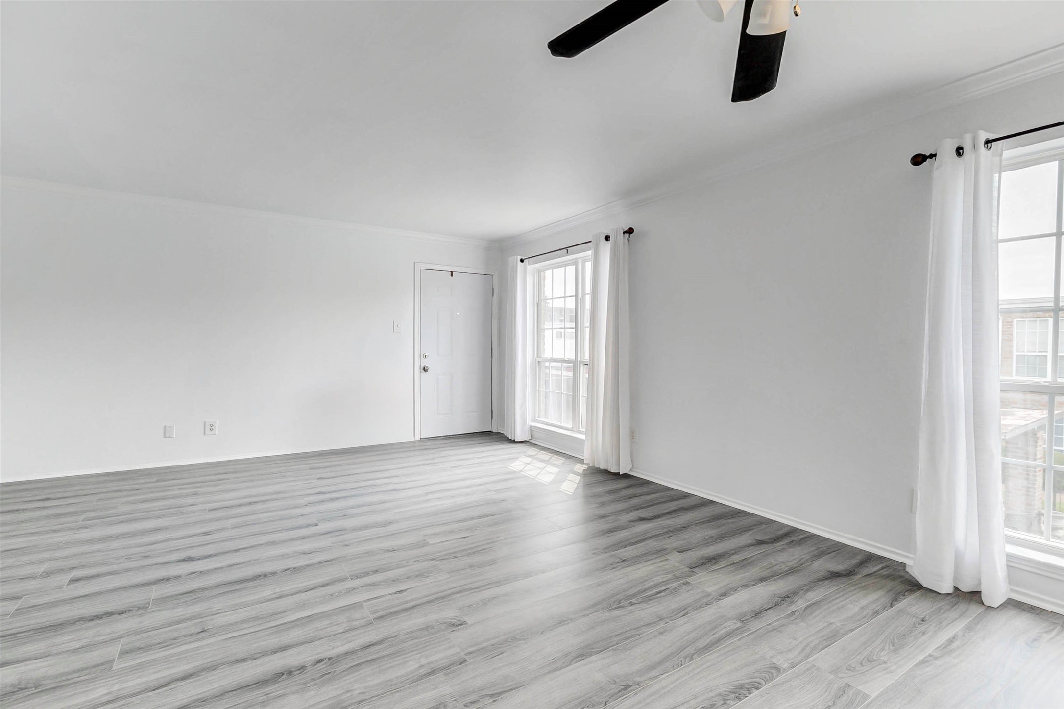 6402 Del Monte Drive, Unit 65 Houston, TX 77057 - Photo 6 of 21 an empty room with wooden floor cabinet and windows
