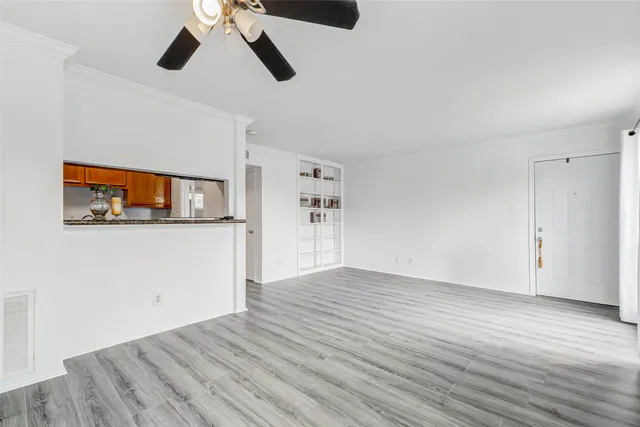 a view of empty room with wooden floor