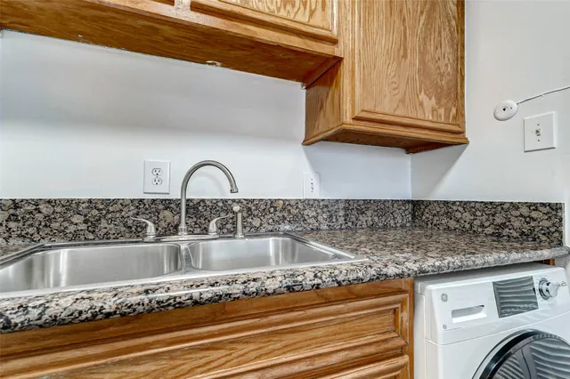 a kitchen with granite countertop a sink and a stove top oven