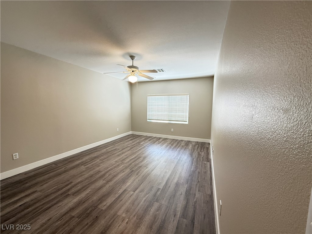 1624 Box Step Drive Henderson, NV 89014 - Photo 16 of 23 Spare room with a ceiling fan, dark wood-style flo