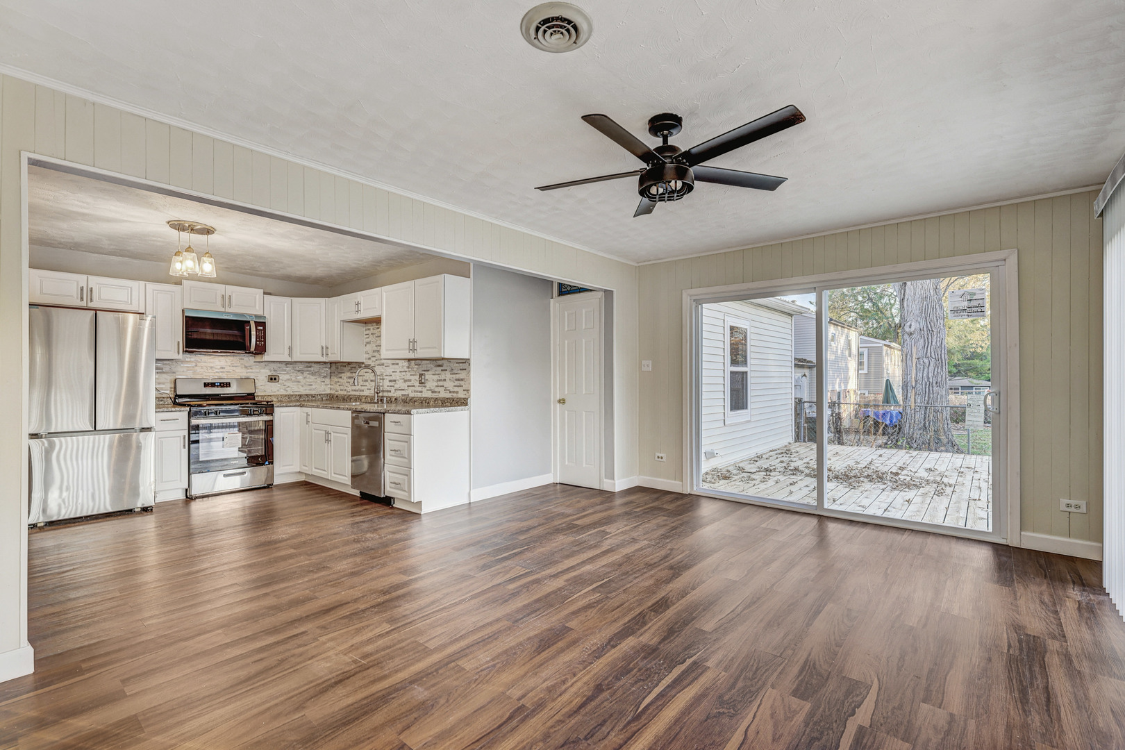 8 Timber Trail Streamwood, IL 60107 - Photo 9 of 27 a view of an empty room with wooden floor and a kitchen