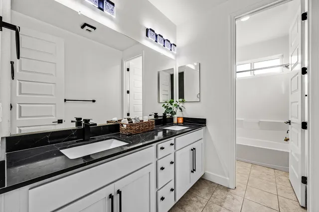 a bathroom with a granite countertop sink a mirror and shower