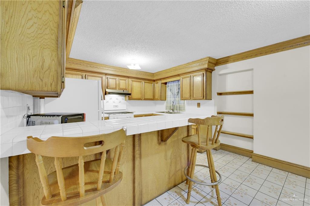 18 Bellas Lane Rio Grande City, TX 78582 - Photo 5 of 28 a kitchen with a table chairs and a refrigerator