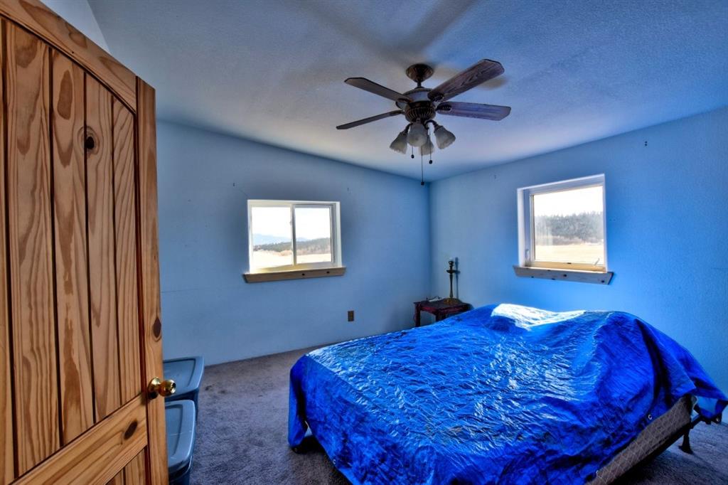 631 Murphy Road Como, CO 80432 - Photo 5 of 21 a bedroom with a bed and a chandelier