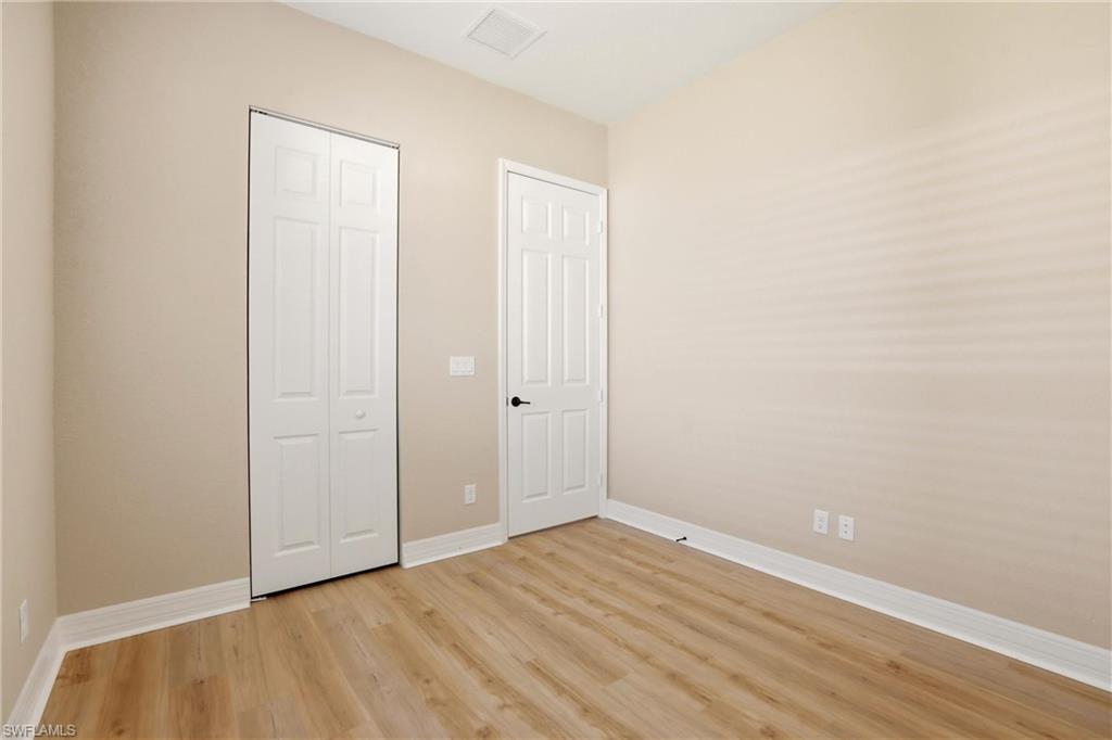 11505 Summerview Way Fort Myers, FL 33913 - Photo 18 of 50 a view of an empty room with wooden floor