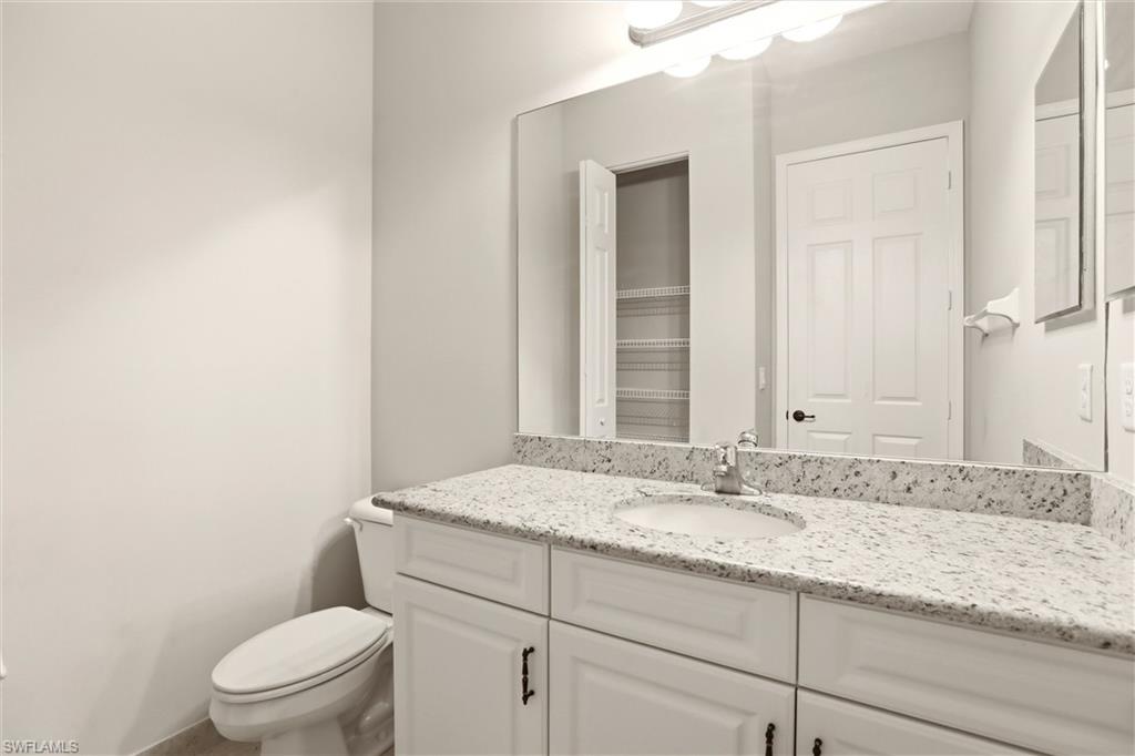 11505 Summerview Way Fort Myers, FL 33913 - Photo 30 of 50 a bathroom with a granite countertop sink a toilet and a mirror