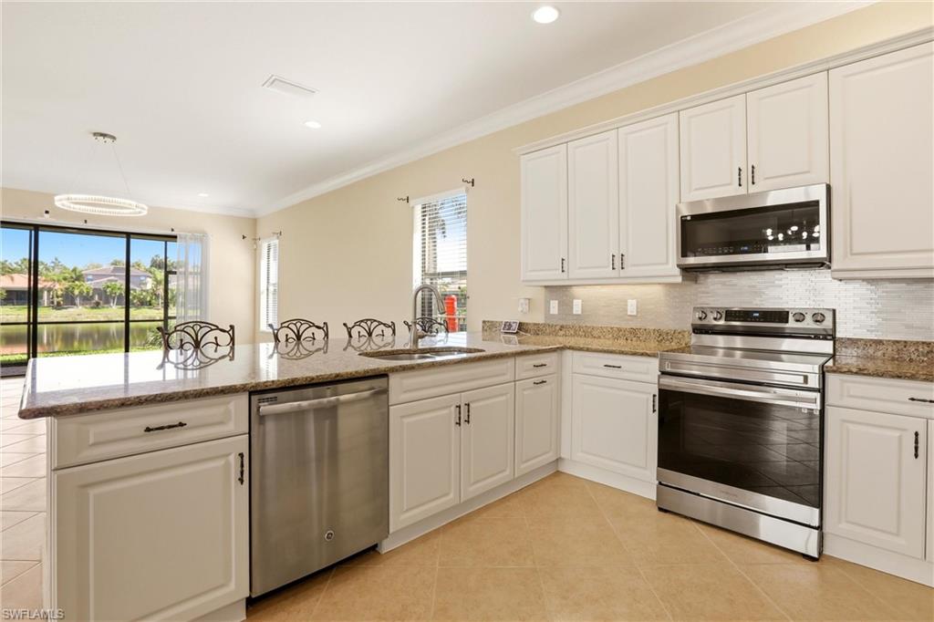 11505 Summerview Way Fort Myers, FL 33913 - Photo 7 of 50 a kitchen with granite countertop white cabinets sink and stainless steel appliances