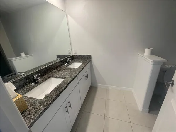 a bathroom with a granite countertop sink and a mirror