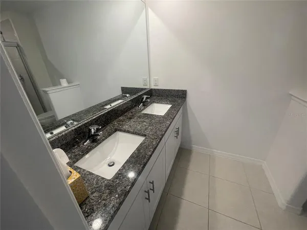 a bathroom with a granite countertop sink and a mirror