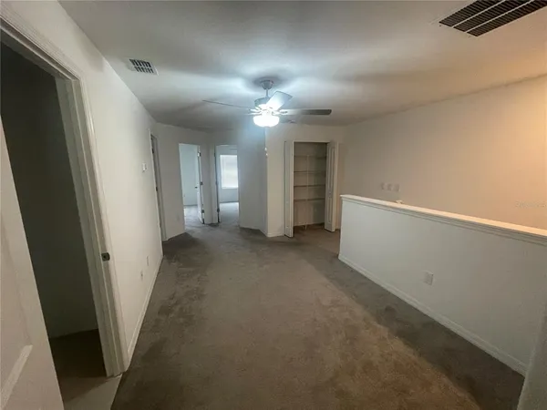an empty room with closet and windows