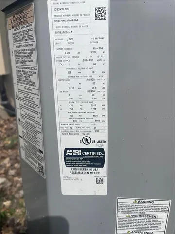 an empty room with a chandelier fan and windows