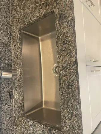a kitchen with granite countertop a refrigerator and a sink