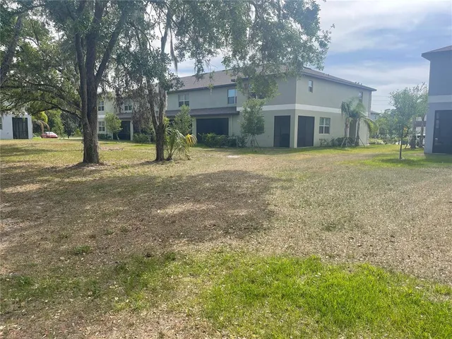 a view of a house with a yard and tree s