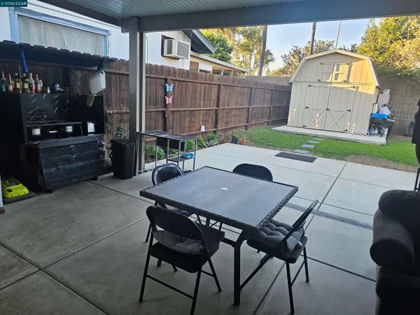 a view of backyard with small cabin and wooden fence