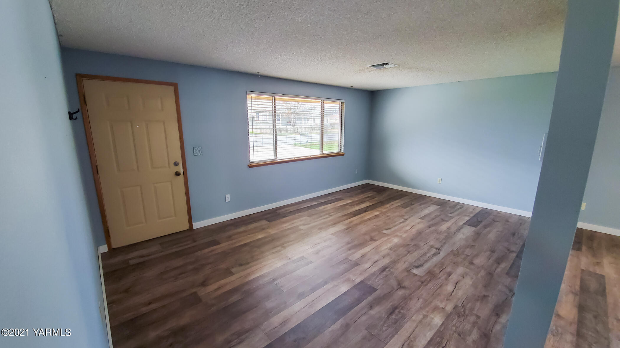 1503 South 27th Avenue Yakima, WA 98902 - Photo 3 of 26 an empty room with wooden floor and windows