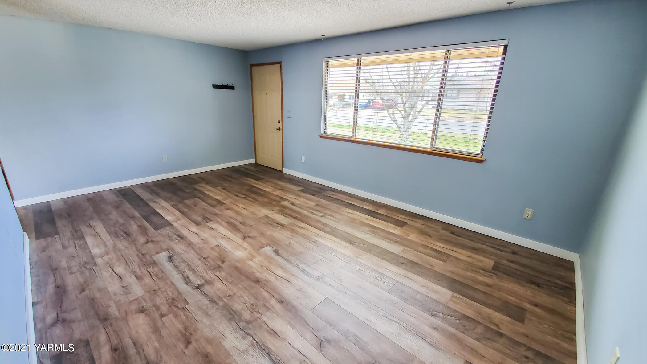 1503 South 27th Avenue Yakima, WA 98902 - Photo 5 of 26 a view of an empty room with wooden floor and a window