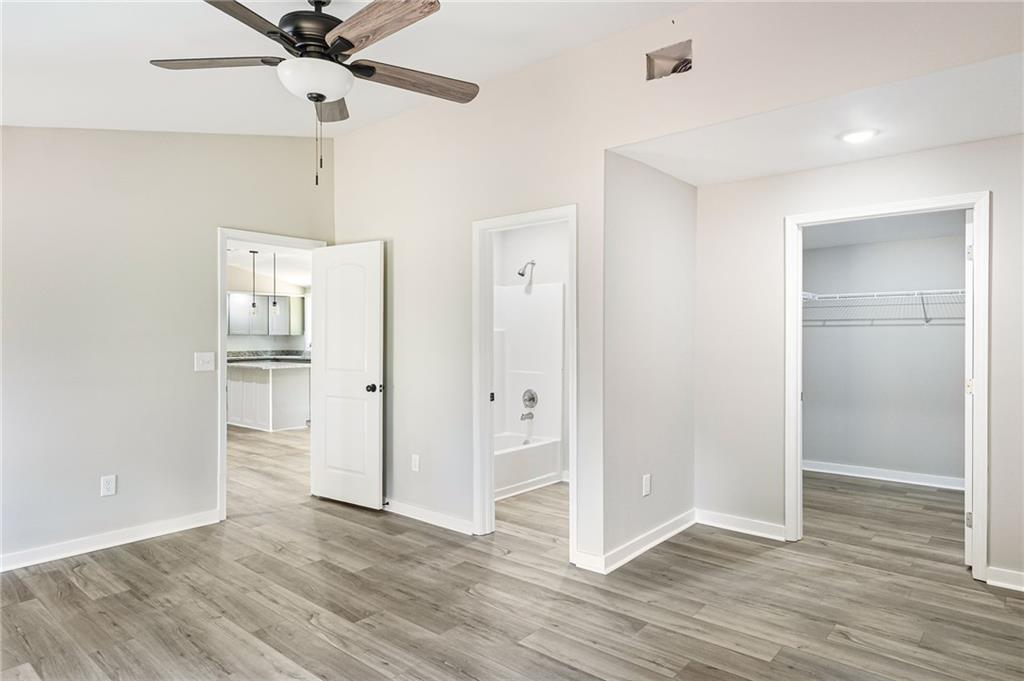 1265 Horsley Mill Road Carrollton, GA 30116 - Photo 12 of 31 a view of an empty room with wooden floor and a ceiling fan