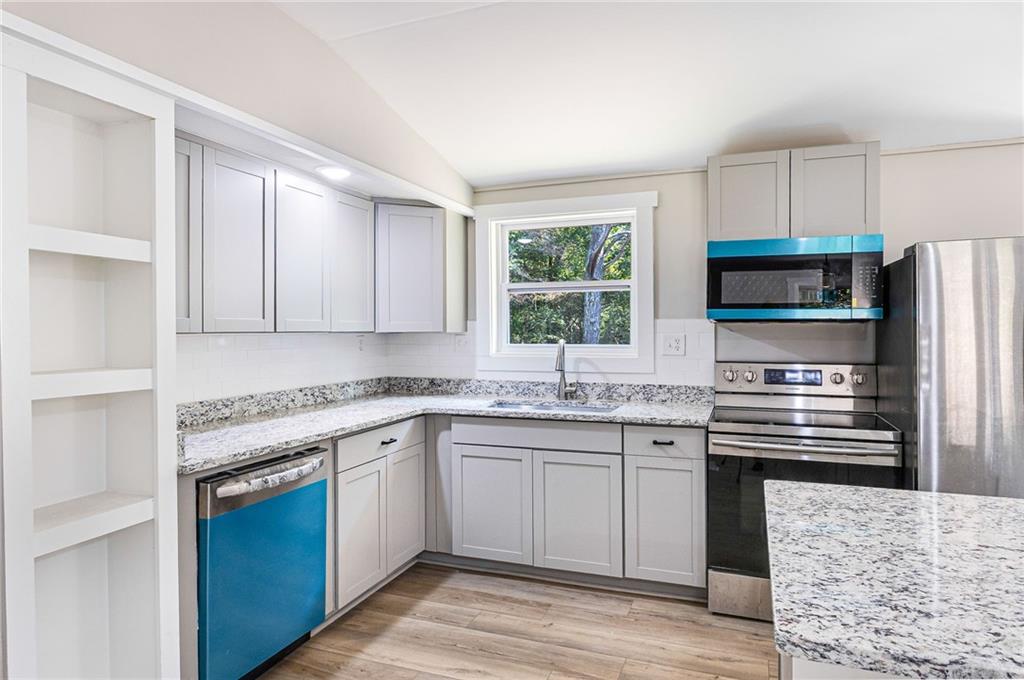 1265 Horsley Mill Road Carrollton, GA 30116 - Photo 16 of 31 a kitchen with stainless steel appliances granite countertop a stove top oven a sink dishwasher and a refrigerator