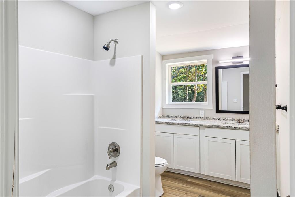 1265 Horsley Mill Road Carrollton, GA 30116 - Photo 10 of 31 a bathroom with a granite countertop toilet a sink and a bathtub