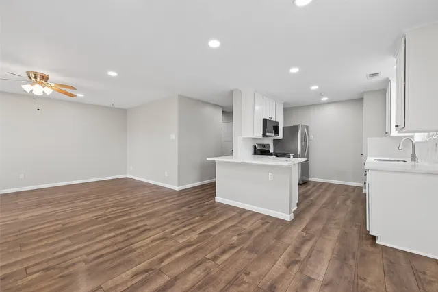 a view of kitchen with wooden floor and electronic appliances
