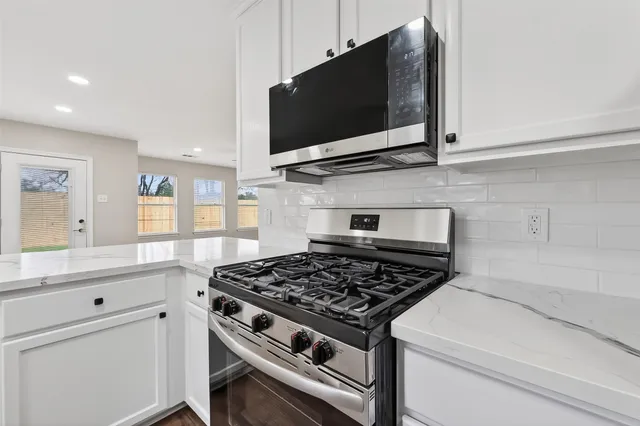 a kitchen with stainless steel appliances a sink dishwasher stove microwave and cabinets