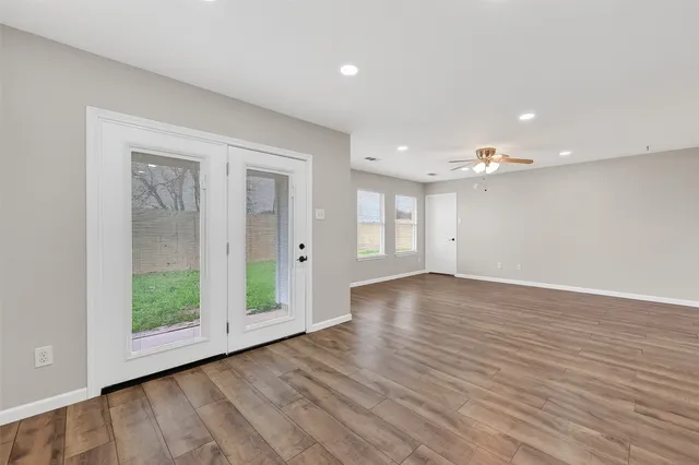 an empty room with wooden floor and a window