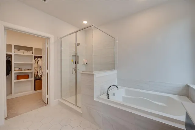 a bathroom with a double vanity sink a mirror and a bathtub