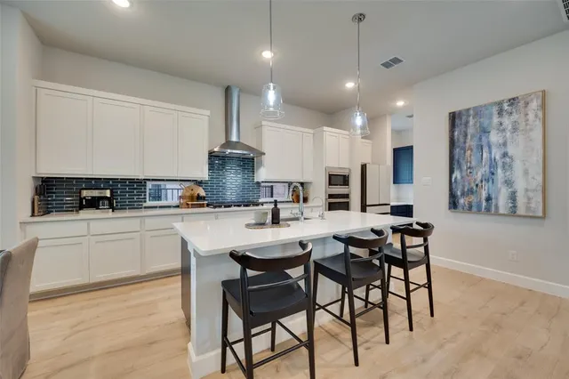 a kitchen with stainless steel appliances granite countertop a stove a sink a microwave a center island and a window