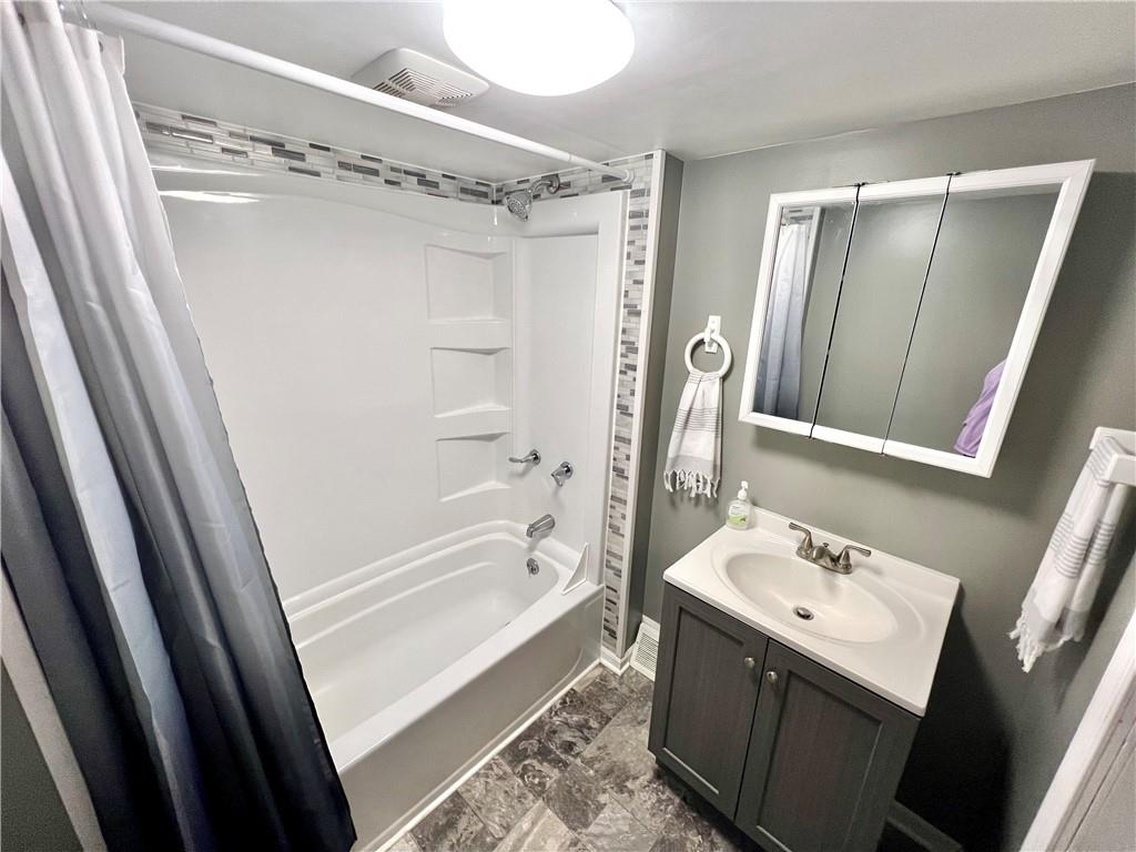 409 1st Street Chestnut Ridge, PA 15422 - Photo 18 of 31 a bathroom with a sink a mirror a bathtub and shower