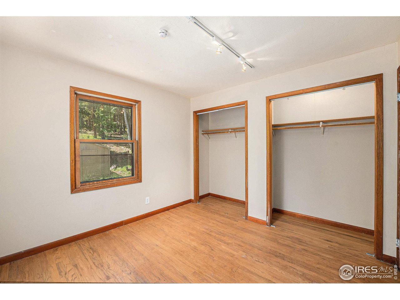 147 St Vrain Trail Ward, CO 80481 - Photo 16 of 31 a view of an empty room with wooden floor and a window