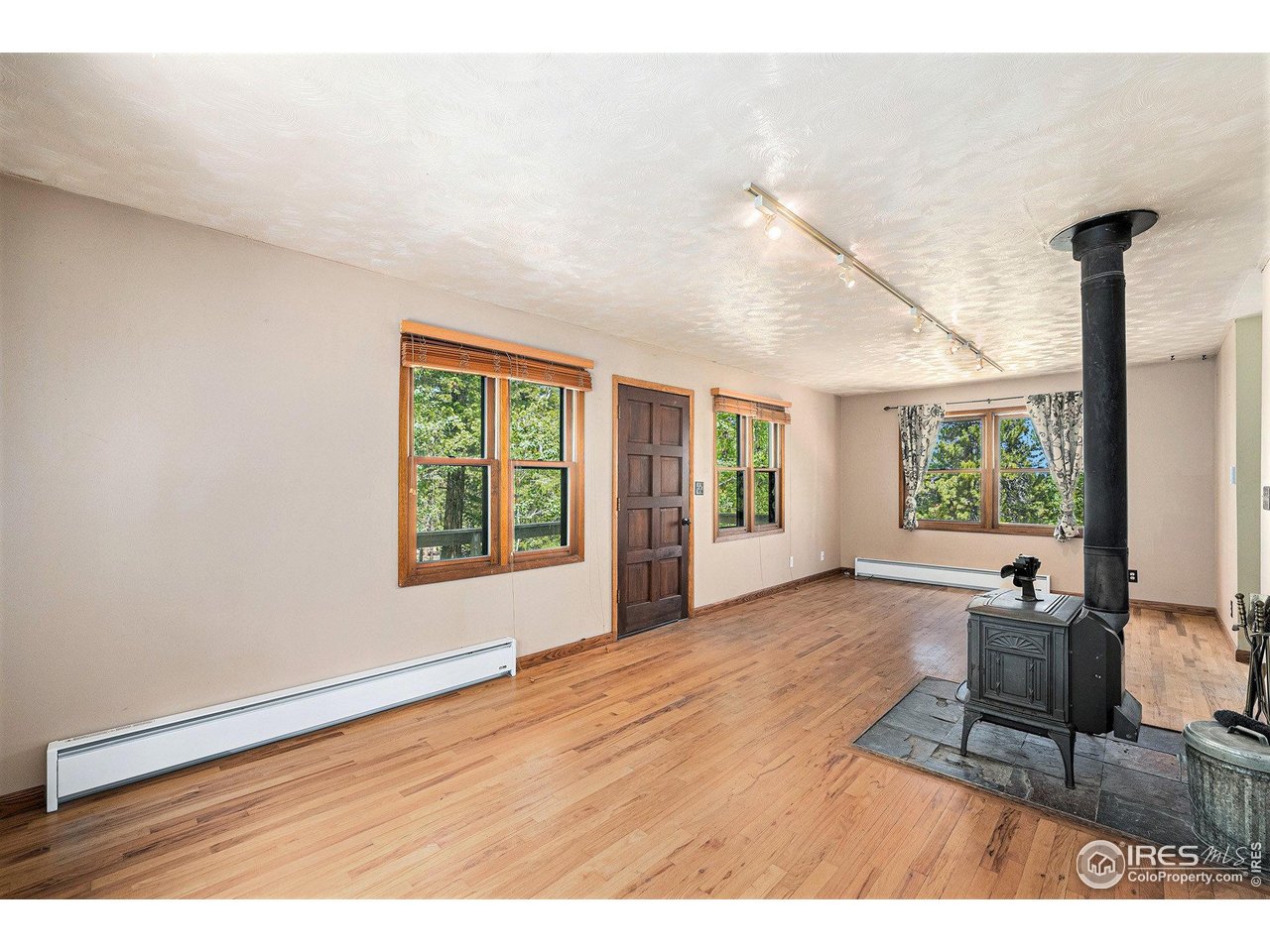 147 St Vrain Trail Ward, CO 80481 - Photo 4 of 31 a view of an empty room with wooden floor and a window