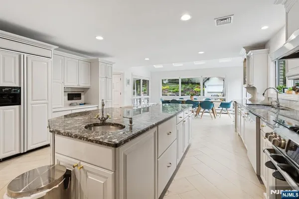 a kitchen with counter top space sink stove and chairs