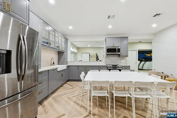 a kitchen with stainless steel appliances kitchen island granite countertop a refrigerator and a stove top oven