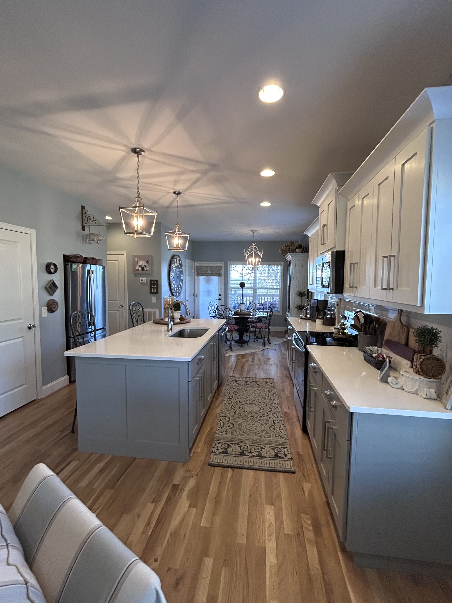207 North Walnut Street Springfield, TN 37172 - Photo 6 of 14 a large room with kitchen island a sink dishwasher a stove a dining table and chairs with wooden floor