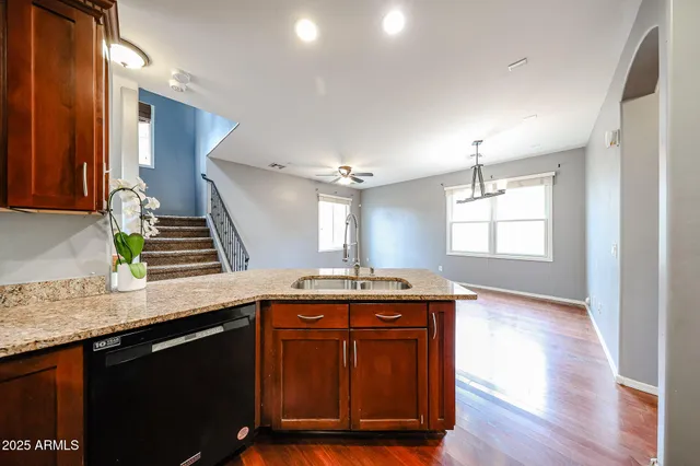 a kitchen with granite countertop a sink cabinets and wooden floor