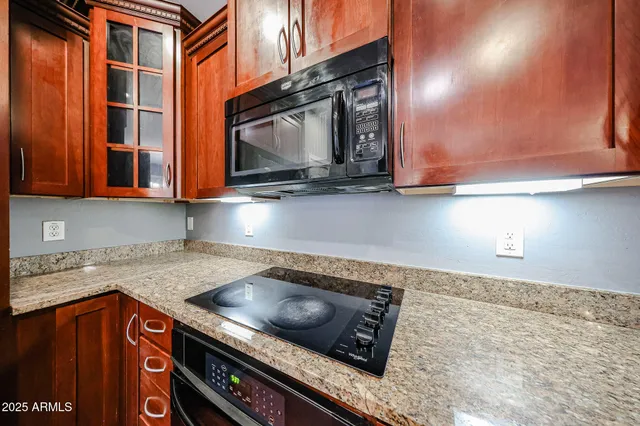 a kitchen with stainless steel appliances granite countertop a stove a microwave and a sink