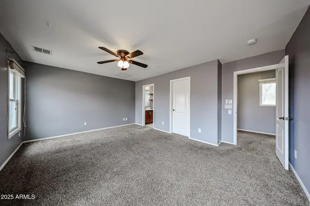 a view of an empty room with a ceiling fan