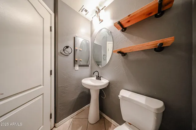 a bathroom with a toilet sink and mirror