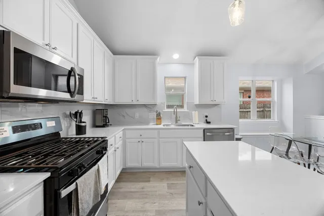 a kitchen with stainless steel appliances granite countertop a sink stove and cabinets