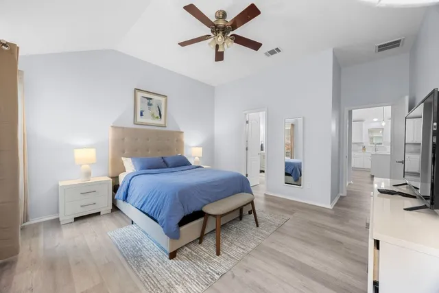 a spacious bedroom with a bed and a flat screen tv