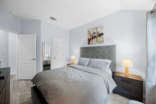 a bedroom with a bed and a painting on the wall