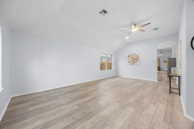 an empty room with windows and fan