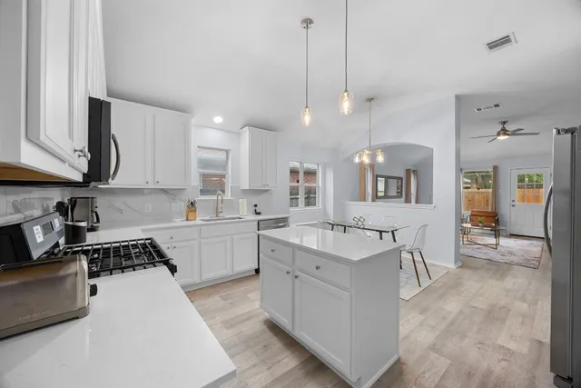 a kitchen with a sink stove and cabinets