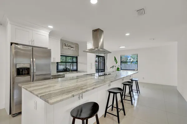 a kitchen with kitchen island granite countertop a counter space and stainless steel appliances