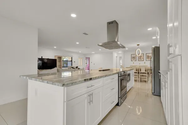 a kitchen with stainless steel appliances granite countertop a sink and a refrigerator